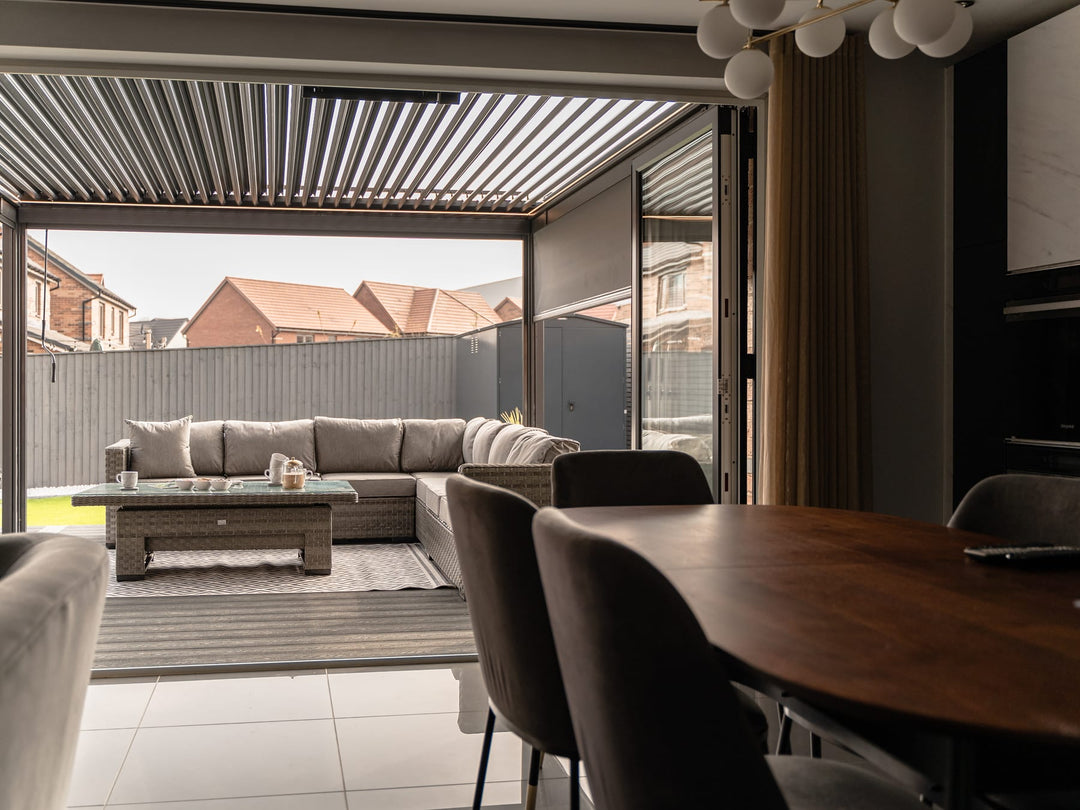 Pergola bioclimatica in alluminio con lamelle orientabili semi-aperte su terrazzo italiano, luce autunnale radente