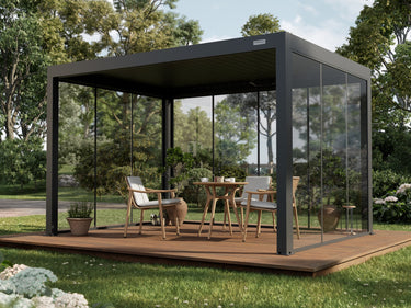 Pergola antracite su una pedana in legno con pareti in vetro fisso e un tavolo da pranzo con sedie